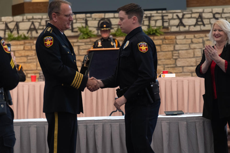 New APD officer Sean Rogers is handed the top cadet award at the 101st Amarillo Police Academy Graduation Thursday at the Amarillo Civic Center.