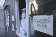 Medical workers in a booth wait for people to come for tests at a coronavirus testing site in Seoul, South Korea, Tuesday, Jan. 19, 2021. (AP Photo/Ahn Young-joon)