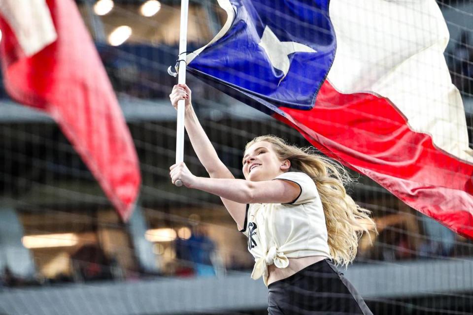 A member of the Texas Rangers Six Shooters team waves the Texas flag during the starting line up introductions of a regular season match up against the Los Angeles Dodgers at Globe Life Field in Arlington, Texas on Saturday, July 22, 2023.