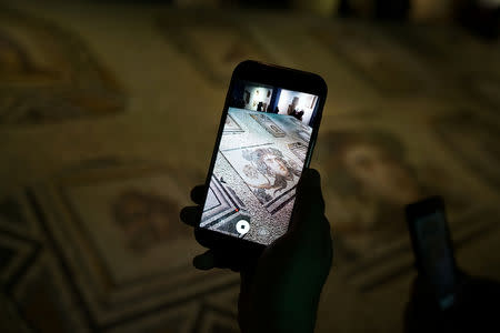Visitors take pictures of the missing pieces of the historic "Gypsy Girl" mosaic on display in an exhibition at their origin in Gaziantep, Turkey, December 8, 2018. REUTERS/Umit Bektas