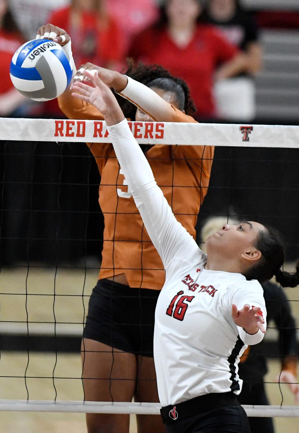Texas' Logan Eggleston, top, blocks the ball against Texas Tech in a Big 12 volleyball match, Sunday, Oct. 2, 2022, at United Supermarkets Arena.