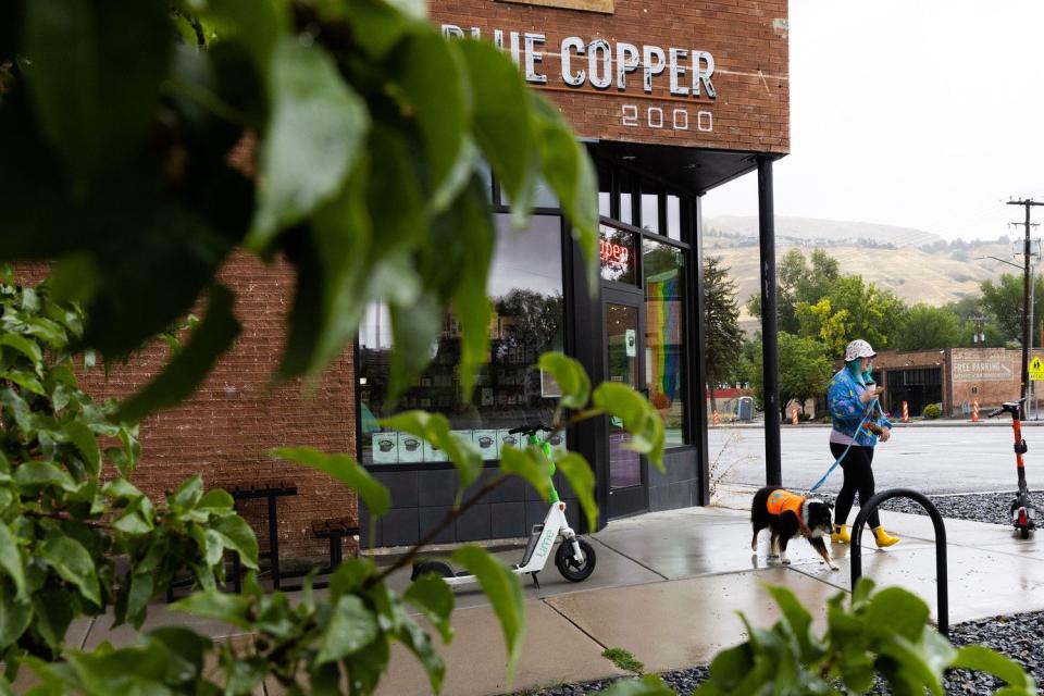 Britt and her dog Harvey walk out of Blue Copper Coffee on a rainy Labor Day in Salt Lake City on Monday.