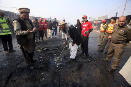 Investigators look for evidence after a suicide bomber blew himself up close to a police checkpoint in Peshawar, Pakistan January 19, 2016. REUTERS/Fayaz Aziz