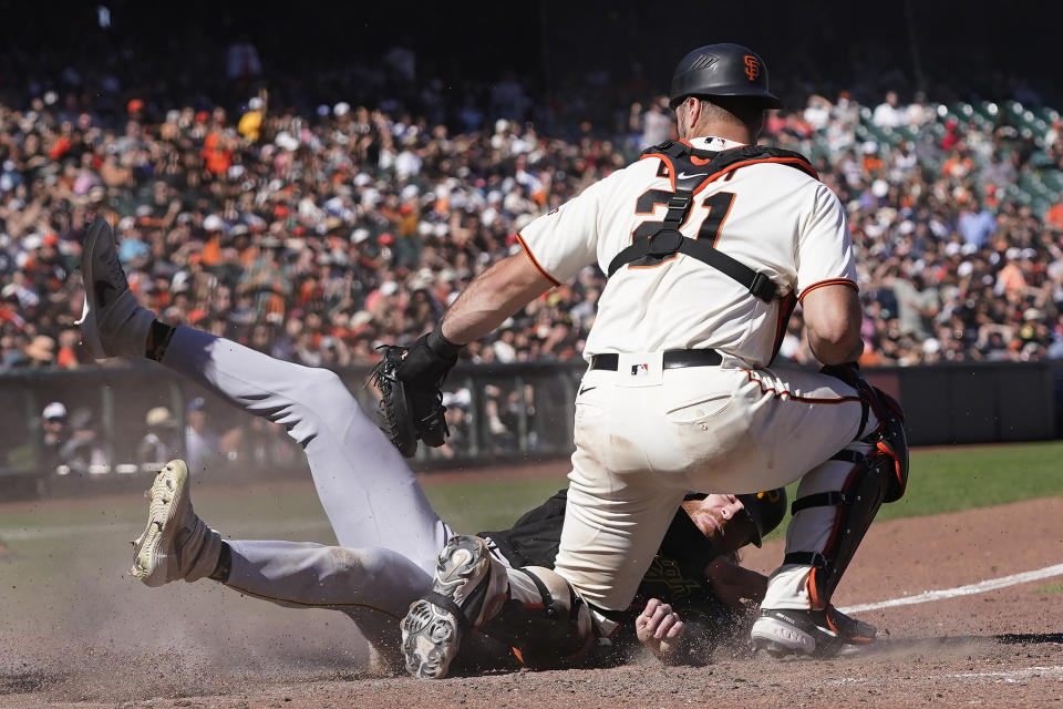 Pittsburgh Pirates' Ben Gamel, bottom, is tagged out at home by San Francisco Giants catcher Joey Bart during the ninth inning of a baseball game in San Francisco, Sunday, Aug. 14, 2022. (AP Photo/Jeff Chiu)