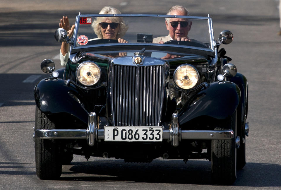 In this March 26, 2019 photo, Prince Charles drives a vintage car with his wife Camilla, Duchess of Cornwall, during a cultural event in Havana, Cuba. The heir to the British throne arrived in Cuba Sunday with an agenda including visits to historic sites, a solar park, organic farm, bio-medical research center, a meeting with entrepreneurs, a cultural gala and a dinner with Cuba's president. (AP Photo/Ramon Espinosa)