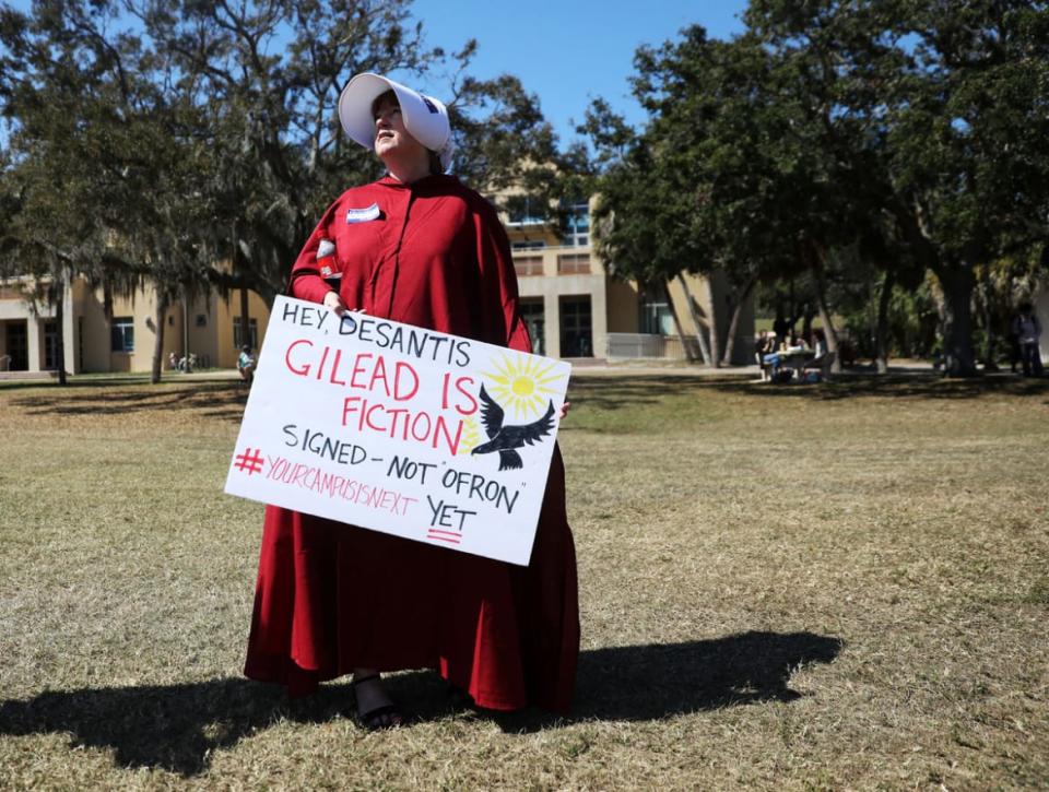 <div class="inline-image__caption"><p>A woman dressed in a costume from the show "The Handmaid's Tale" holds a sign during a staged walkout at the New College of Florida, a public liberal arts college, to protest against a proposed wide-reaching legislation that would ban gender studies majors and diversity programs at Florida universities, in Sarasota, Florida. </p></div> <div class="inline-image__credit">Octavio Jones/Reuters</div>