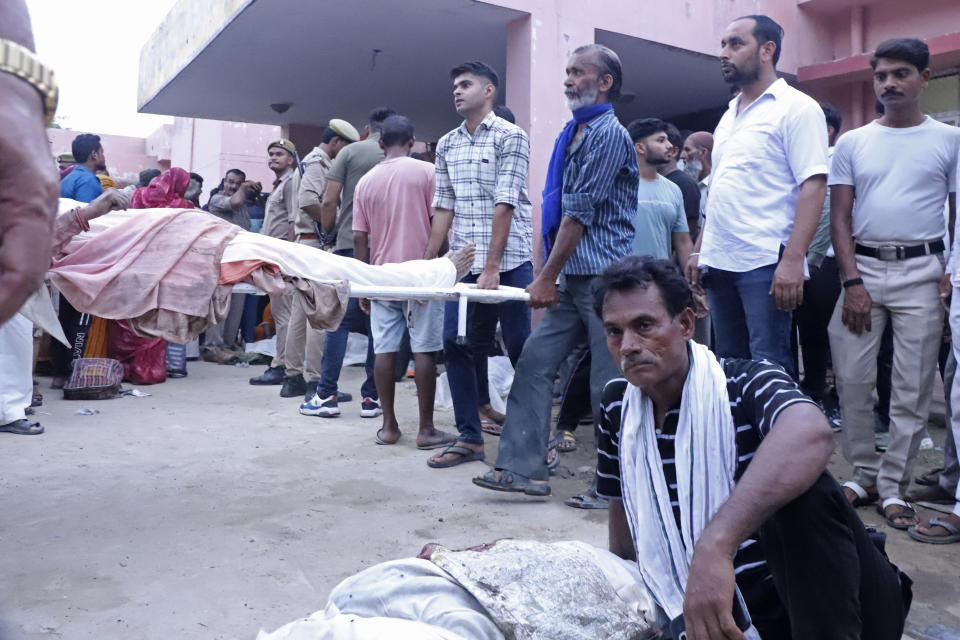 Relatives carry body of a man on a stretcher outside the Sikandrarao hospital in Hathras district about 350 kilometers (217 miles) southwest of Lucknow, India, Tuesday, July 2, 2024. At least 60 people are dead and scores are injured after a stampede at a religious gathering of thousands of people in northern India, officials said Tuesday.(AP Photo/Manoj Aligadi)