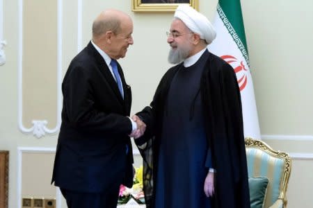 FILE PHOTO: Iranian President Hassan Rouhani shakes hands with French Foreign Affairs Minister Jean-Yves Le Drian, in Tehran, Iran, March 5, 2018. President.ir/Handout via REUTERS