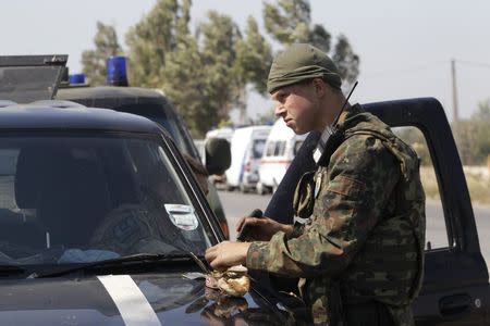 A soldier of Ukrainian self-defence battalion "Azov" eats at a checkpoint in the southern coastal town of Mariupol, September 5, 2014. REUTERS/Vasily Fedosenko