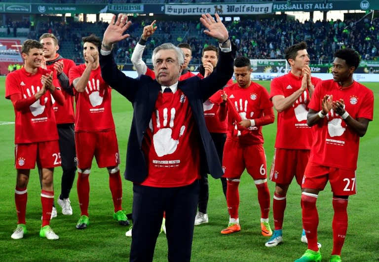 Bayern Munich's coach Carlo Ancelotti (C) and his team celebrate becoming the new German champion on April 29, 2017 in Wolfsburg, northern Germany