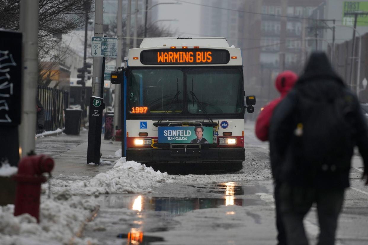Snow falls as migrants continue to be housed by the city in "warming" buses in the 800 block of South Desplaines Street during a winter storm Friday, Jan. 12, 2024, in Chicago. (AP Photo/Erin Hooley)