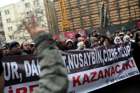 A demonstrator flashes the V-sign during a protest against security operations in the Kurdish dominated southeast, in central Istanbul, Turkey January 3, 2016. The banner partly reads the names of Kurdish dominated southeastern towns and "Resistance will win!" REUTERS/Yagiz Karahan