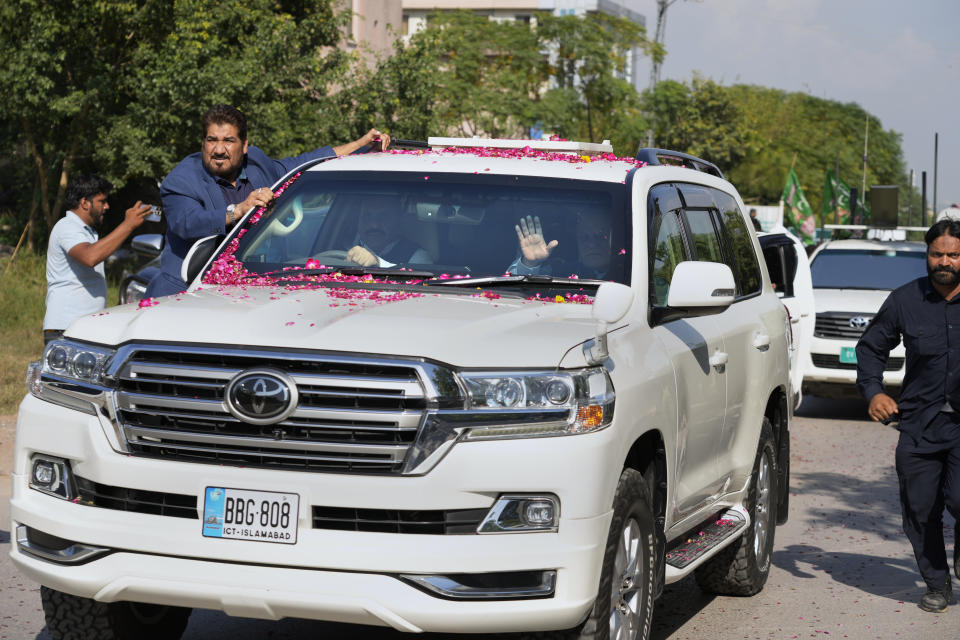 Pakistan's former Prime Minister Nawaz Sharif, center in vehicle, waves to his supporters as he leaves after appearing in a court in Islamabad, Pakistan, Tuesday, Oct. 24, 2023. Sharif returned to Pakistan on last Saturday, ending his four years of self-imposed exile in London. Sharif is facing multiple legal challenges. A Pakistani federal court on last Thursday granted him bail until Oct. 24, giving him protection from arrest until then. (AP Photo/Anjum Naveed)