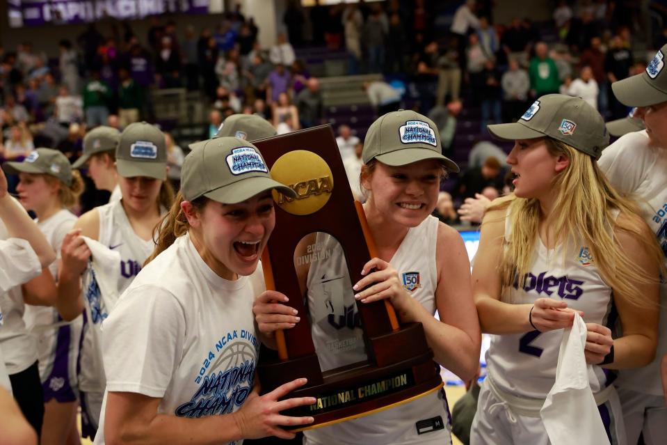 Chloe Teter (center right) holds the Division 3 women's basketball national title trophy after winning the final with NYU