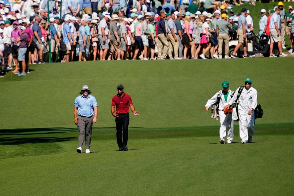 Neal Shipley and Tiger Woods talk as they walk down the No. 7 fairway during the final round of the Masters.