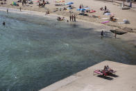 Sunbathers enjoy the beach in Palma de Mallorca, Spain, Sunday, July 26, 2020. Britain has put Spain back on its unsafe list and announced Saturday that travelers arriving in the U.K. from Spain must now quarantine for 14 days. The move by the UK taken without forewarning has caught travelers off guard. (AP Photo/Joan Mateu)