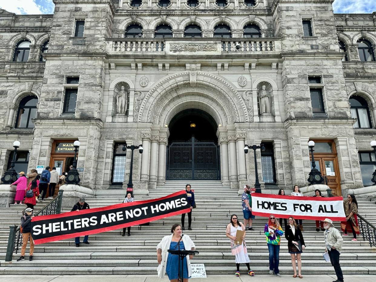 Members of a group called the Housing Justice Project rally at the B.C. Legislature on May 7, 2024. The group, made up of researchers and people with lived experience in homelessness, says Greater Victoria needs thousands of additional units of truly affordable housing in order to end homelessness. (Kathryn Marlow/CBC - image credit)