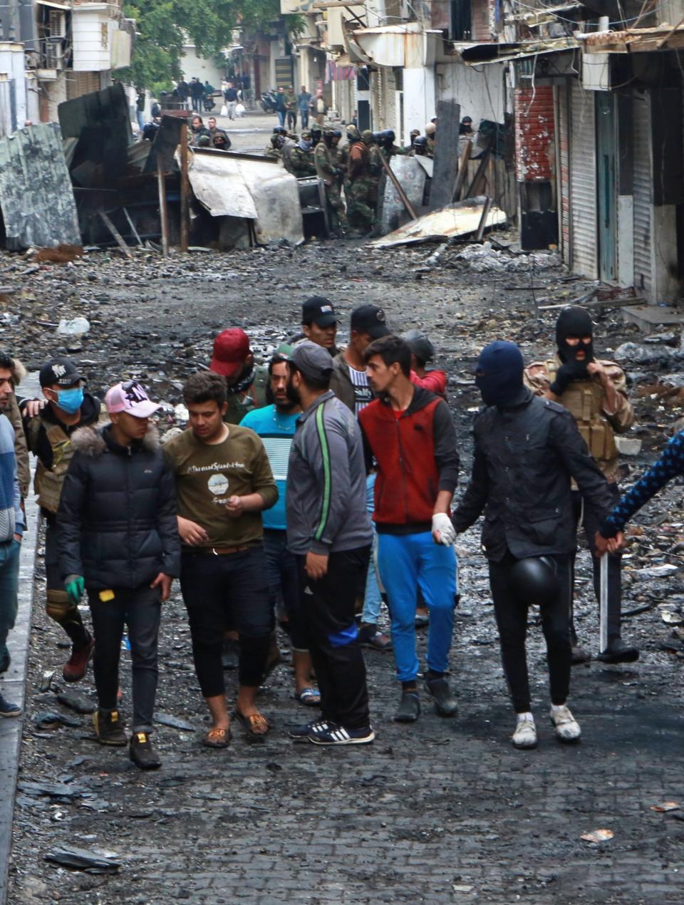 Anti-government protesters and security forces face-off on River Street during ongoing protests in Baghdad, Iraq, Tuesday, Dec. 3, 2019. At least 400 people have died since the leaderless uprising shook Iraq on Oct. 1, with thousands of Iraqis taking to the streets in Baghdad and the predominantly Shiite southern Iraq decrying corruption, poor services, lack of jobs and calling for an end to the political system that was imposed after the 2003 U.S. invasion. (AP Photo/Khalid Mohammed)