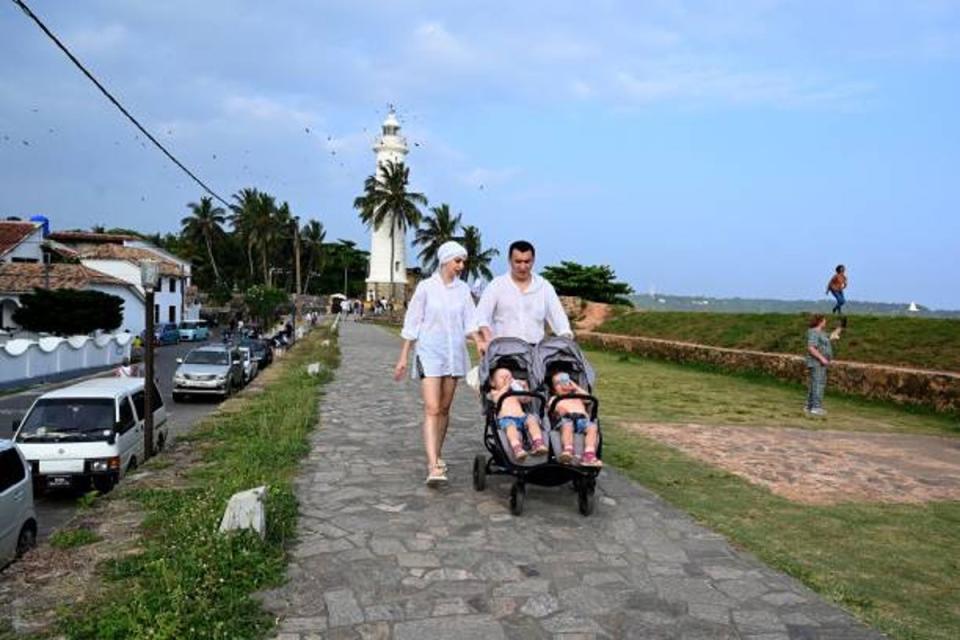 Tourists push a stroller along Galle Fort in Gallehas after Russia’s invasion of Ukraine stranded many people on the tropical island (AFP via Getty Images)