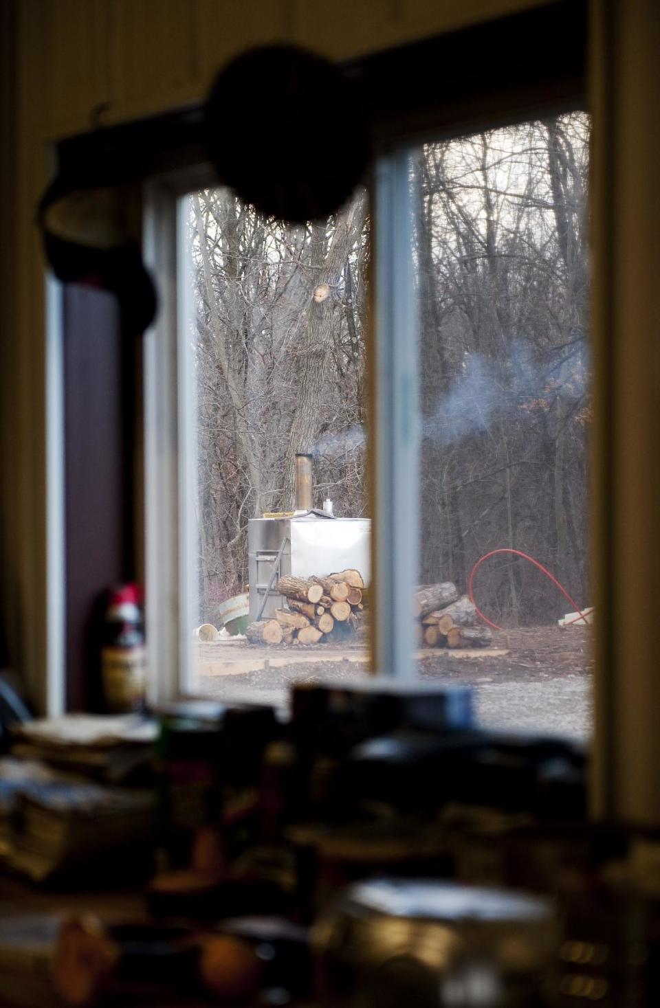 A wood burning stove burns outside that heats Darwin Woods' work shop Friday, Feb. 21, 2014, at his home near Clark, Mo. Proposed regulations from the U.S. Environmental Protection Agency would significantly reduce the amount of particle pollution allowed from the smokestacks of new residential wood-powered heaters. The proposed regulations have sparked a backlash from some rural residents, lawmakers and manufacturers who fear it could close the damper on one of the oldest ways of warming homes on cold winter days. (AP Photo/L.G. Patterson)