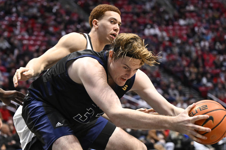 UC Irvine forward Dean Keeler (31) grabs a rebound in front of San Diego State forward Elijah Saunders (25) during the second half of an NCAA college basketball game Saturday, Dec. 9, 2023, in San Diego. (AP Photo/Denis Poroy)
