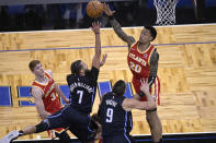 Orlando Magic guard Michael Carter-Williams (7) goes up for a shot between Atlanta Hawks guard Kevin Huerter (3) and forward John Collins (20) during the second half of an NBA basketball game Wednesday, March 3, 2021, in Orlando, Fla. (AP Photo/Phelan M. Ebenhack)