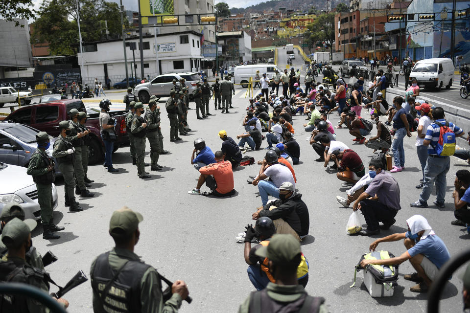 Members of the Bolivarian National Guarde explain proper mask use to non-compliant pedestrians and peddlers on a street of the Petare neighborhood of Caracas, Venezuela, Wednesday, July 29, 2020, amid efforts to contain the spread of the new coronavirus. (AP Photo/Matias Delacroix)