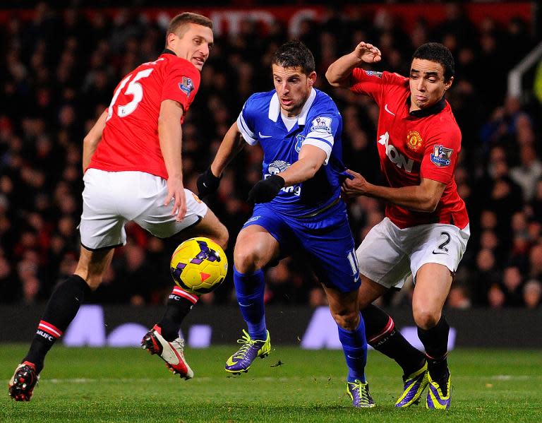 Everton's Kevin Mirallas (C) fights for the ball with Manchester United's Rafael (R) and Nemanja Vidic during their English Premier League match at Old Trafford in Manchester, on December 4, 2013