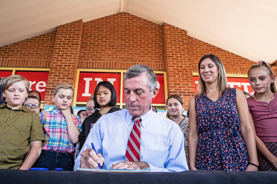Delaware Gov. John Carney, center, accompanied by fourth grade teacher Leanna Vitti, to his right, and Vitti's students, signs a bill banning smoking in cars with children under 16 years old at Wilbur Elementary in Red Lion on Wednesday, Sept. 20, 2023. Vitti has led the efforts with her class in support of this legislation.