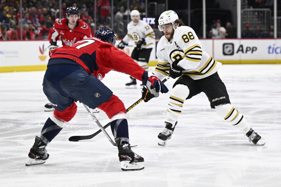 Boston Bruins right wing David Pastrnak (88) skates with the puck against Washington Capitals defenseman Trevor van Riemsdyk (57) during the second period of an NHL hockey game, Monday, April 15, 2024, in Washington. (AP Photo/Nick Wass)