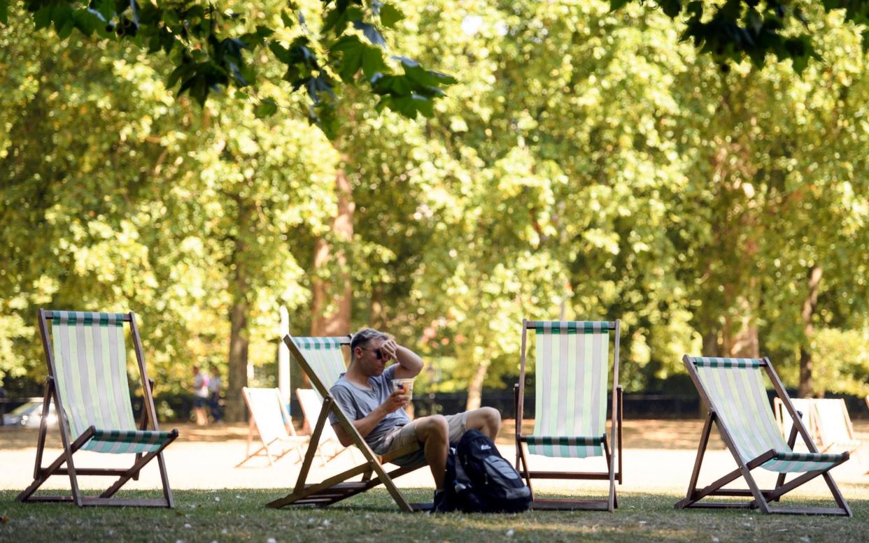 A man wipes sweat from his forehead while sheltering in the shade in London's St James's Park, as the ongoing heatwave means nearly all parts of the UK are seeing above average temperatures - London News Pictures Ltd