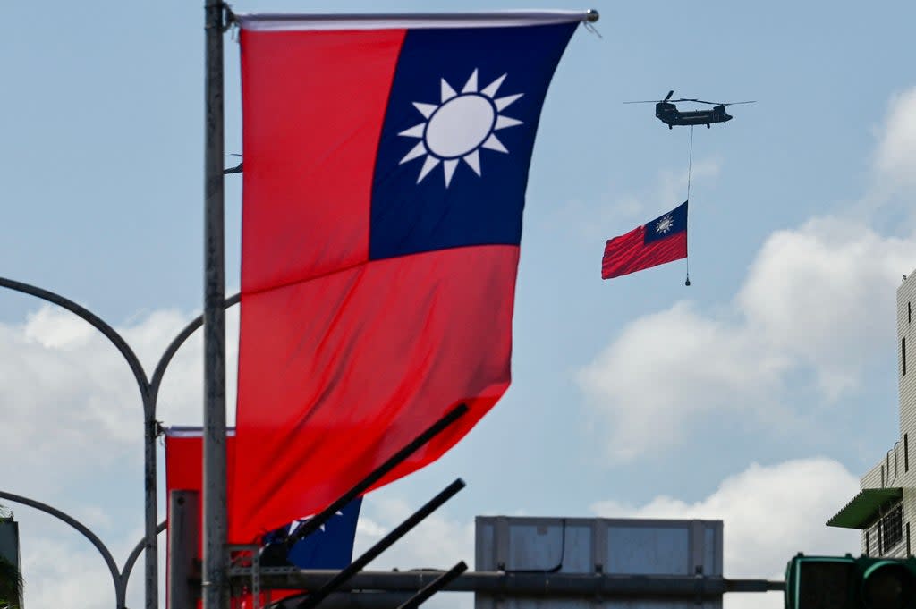 A CH-47 Chinook helicopter carries a Taiwan flag during national day celebrations in Taipei on 10 October 2021 (AFP via Getty Images)