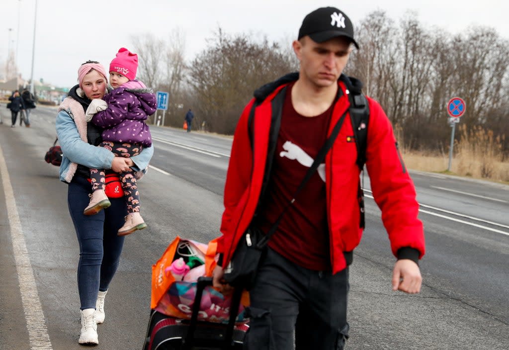 People flee from Ukraine at the Hungarian-Ukrainian border on Thursday  (Reuters)