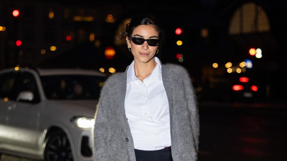 Mariona Autran wears  grey cardigan, blazer, micro shorts, red tights, heels, bag outside Remain during the Copenhagen Fashion Week