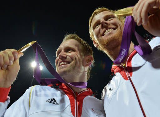 Germany's Jonas Reckermann (R) and Julius Brink (L) pose with their gold medals after winning against Brazil in the men's beach volleyball final match on The Centre Court at Horse Guards Parade in London during the London 2012 Olympics Games