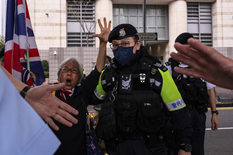 Activist known as 'Grandma Wong' is surrounded by police outside court on the verdict day of a trial involving protesters who stormed the Legislative Council during the pro-democracy protests in 2019, in Hong Kong, Thursday, Feb. 1, 2024. A Hong Kong court on Thursday convicted four people for rioting over the storming of the city's legislative council building at the height of the anti-government protests more than four years ago. (AP Photo/Louise Delmotte)