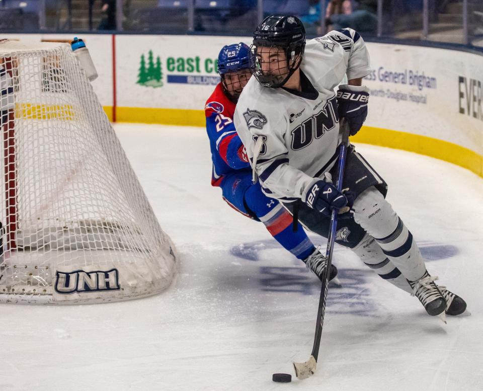 UNH defenseman Luke Reid skates with the puck around the net during Wednesday's Hockey East first-round game against UMass-Lowell at the Whittemore Center. UNH advanced to the quarterfinals at Maine with a 1-0 win.