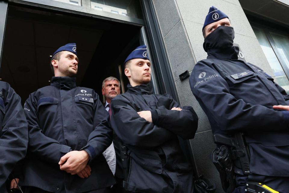 Far-right Flemish separatist party Vlaams Belang member Filip Dewinter stands behind police officers at the entrance (REUTERS)