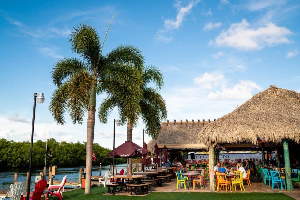 A palm-thatched tiki hut, colorful chairs and lawn line the back of Miceli's on Matlacha. The restaurant overlooks Matlacha Pass Aquatic Preserve.