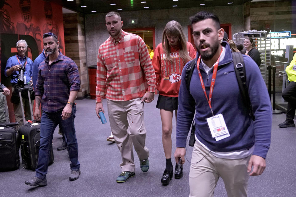 FILE - Kansas City Chiefs tight end Travis Kelce, center left, and singer Taylor Swift leave Arrowhead Stadium after an NFL football game between the Chiefs and the Los Angeles Chargers, Oct. 22, 2023, in Kansas City, Mo. A friendship bracelet with a phone number: that's how Kelce planned to woo Swift when he went to her Eras Tour concert stop in the Missouri capital. The romance that united sports and music fans, a celestial wonder that drew millions of eyes skyward and a long overdue homecoming for some Native American tribes were just some of the moments that inspired us and brought joy in 2023. (AP Photo/Charlie Riedel, File)