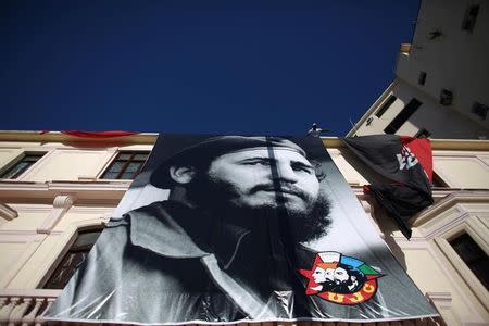 A man hangs a photograph of Cuba's former President Fidel Castro in Havana, Cuba, August 11, 2016. REUTERS/Alexandre Meneghini