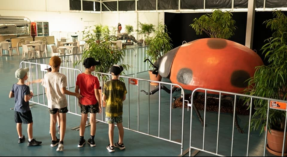 Kids look at a giant ladybug sculpture at Monster Creature World Perth.