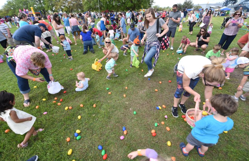 Kids run out to look for eggs during one of the many egg hunts at the Battleship Easter Egg Hunt Carnival at Battleship Park in Wilmington, N.C., Friday, April 14, 2017.