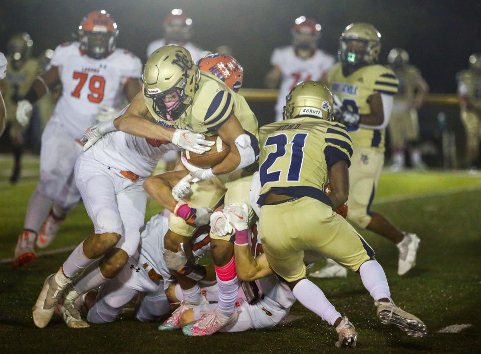 Mountain Lakes' defense brings down Morris Catholic's James Conigliaro during the first half of a SFC National White football game at Morris Catholic High School on October 22, 2021.  Alexandra Pais/ for the Daily Record