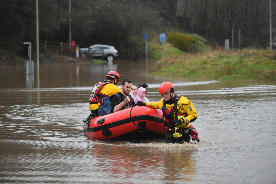 Rescue operations underway and a family is taken to safety, after flooding in Nantgarw, Wales on Sunday. (PA)