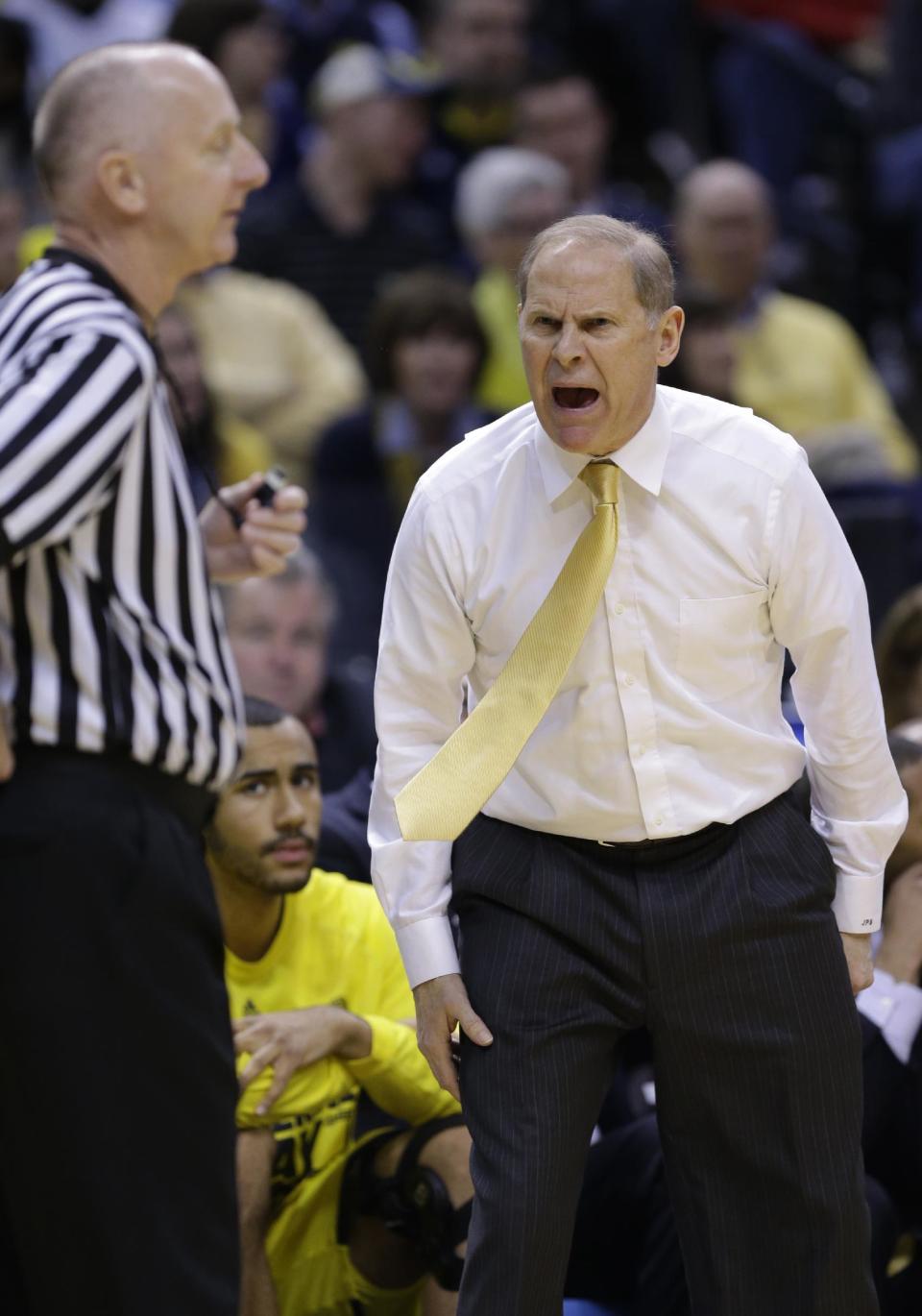 Michigan head coach John Beilein, right, argues a call with an official in the first half of an NCAA college basketball game against Michigan State in the championship of the Big Ten Conference tournament on Sunday, March 16, 2014, in Indianapolis. (AP Photo/Michael Conroy)