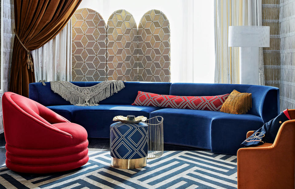 living room with blue sofa, red chair and graphic blue rug