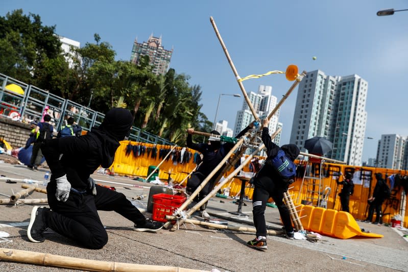 Student protesters use an improvised slingshot to fling tennis balls across a barricade as leisure at Hong Kong Baptist University, Hong Kong