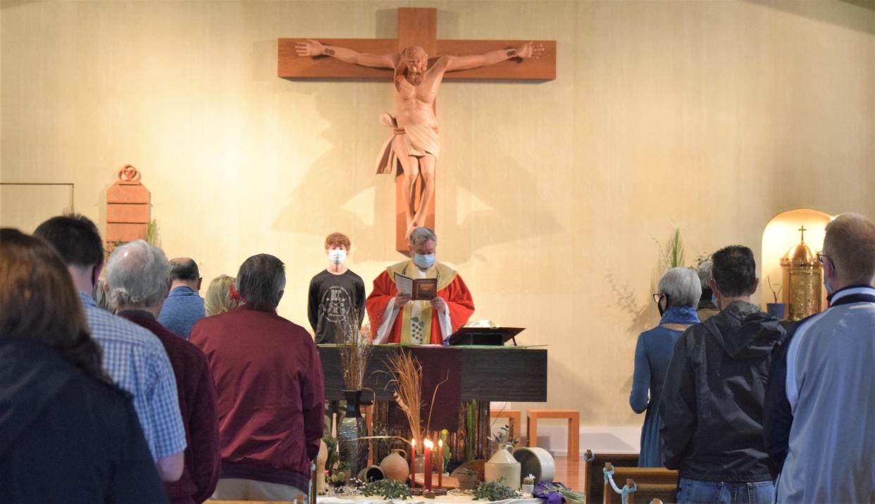 Father Ron Aubry reads the opening prayer of mass on Palm Sunday at St. Peter Catholic Church in Millersburg.