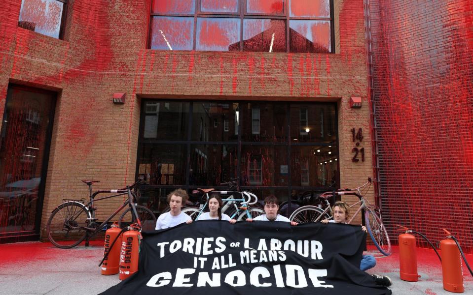 Activists from Youth Demand protest outside Labour's headquarters in London after spraying red paint on the building